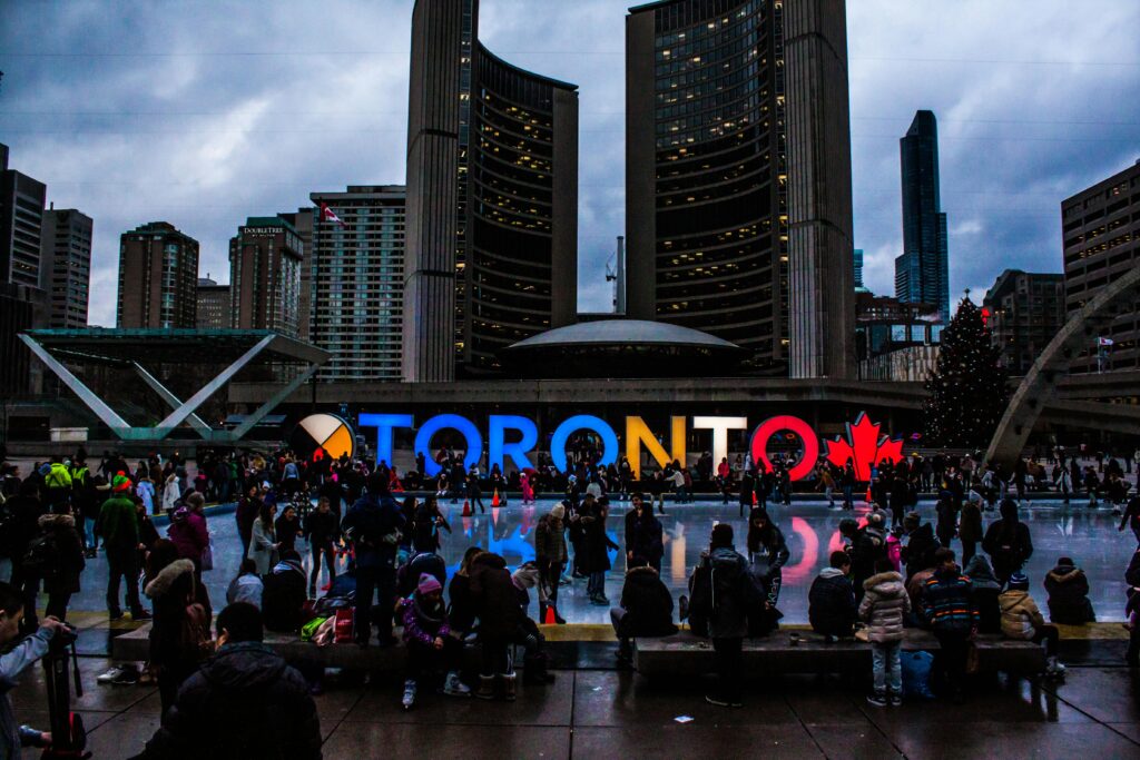 Downtown Toronto skyline at dusk featuring the illuminated Toronto sign at Nathan Phillips Square - home to businesses served by Alliance Answer's premium B2B answering services