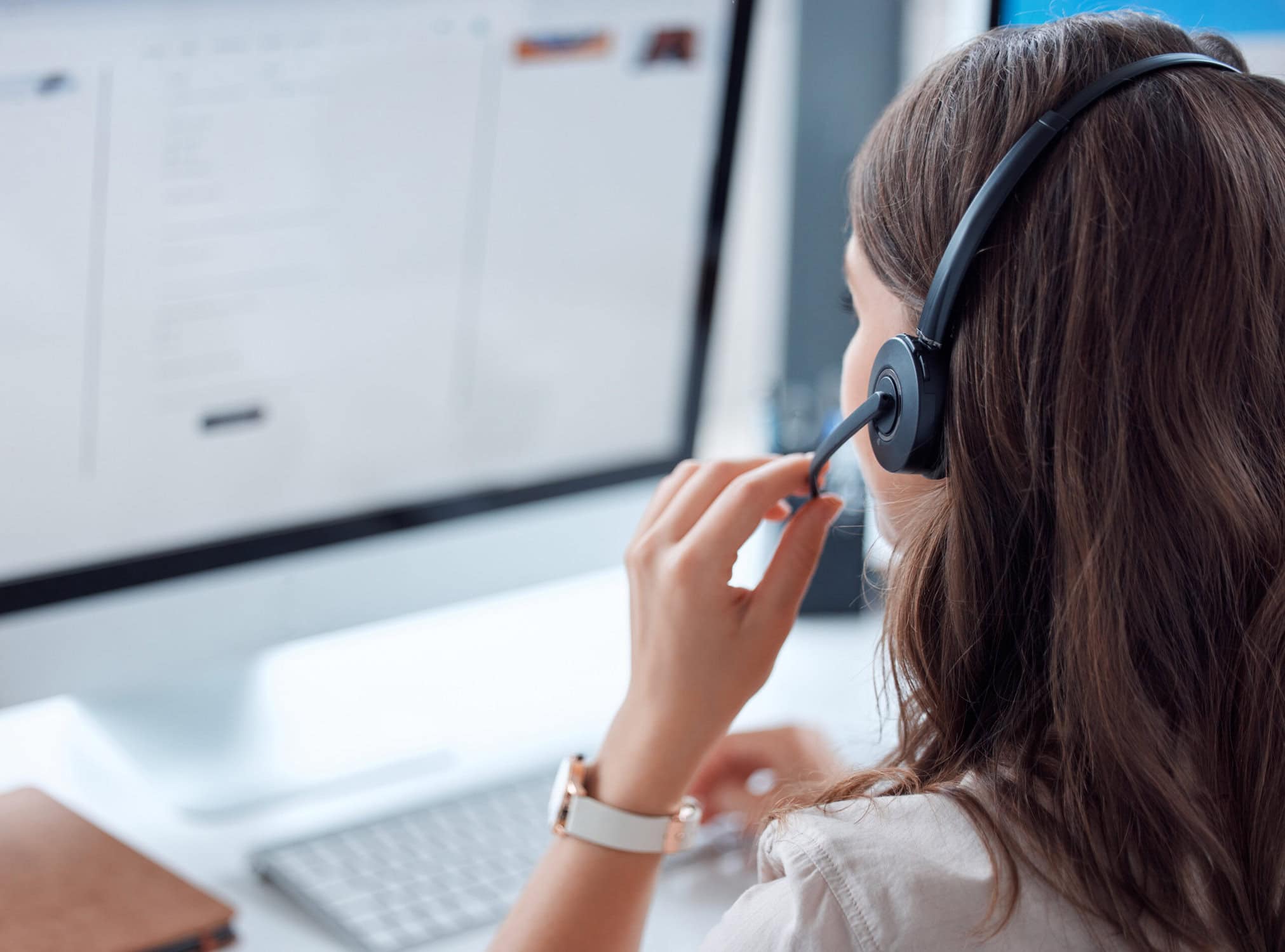 Customer support, call center or answering service and back of female agent working on online consultation in the office. Answering service , communication planning crm with headset and computer in workplace